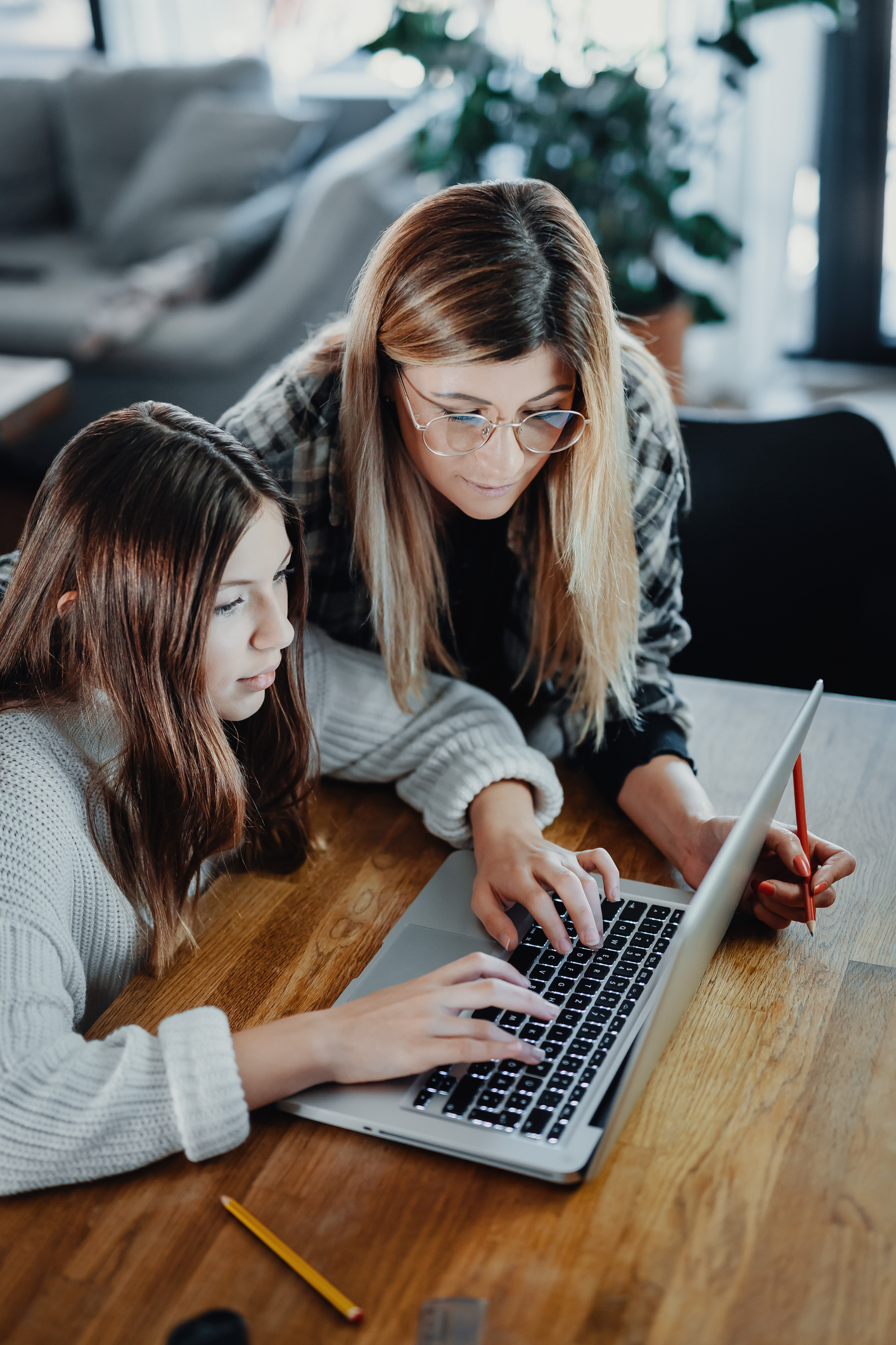 Mother and child doing homeschooling, e-learning at home
