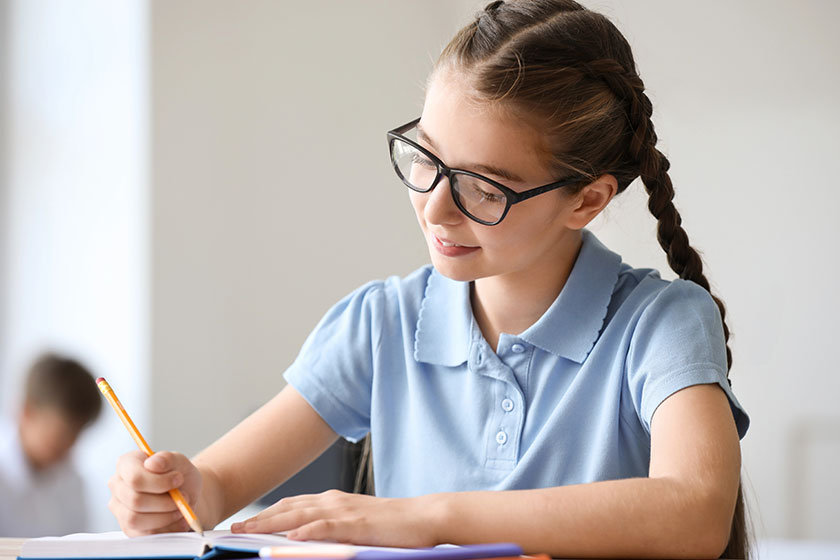 Cute little girl during lesson in classroom