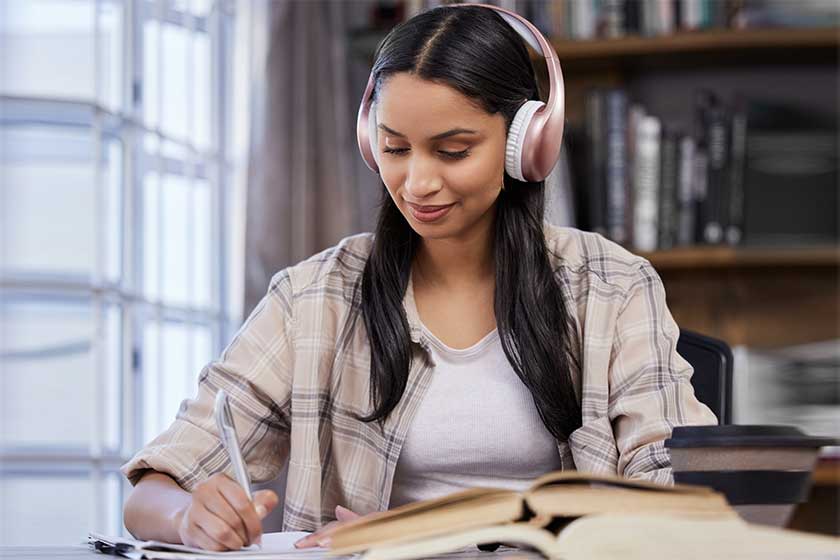 Headphones, study and girl with notebook in library