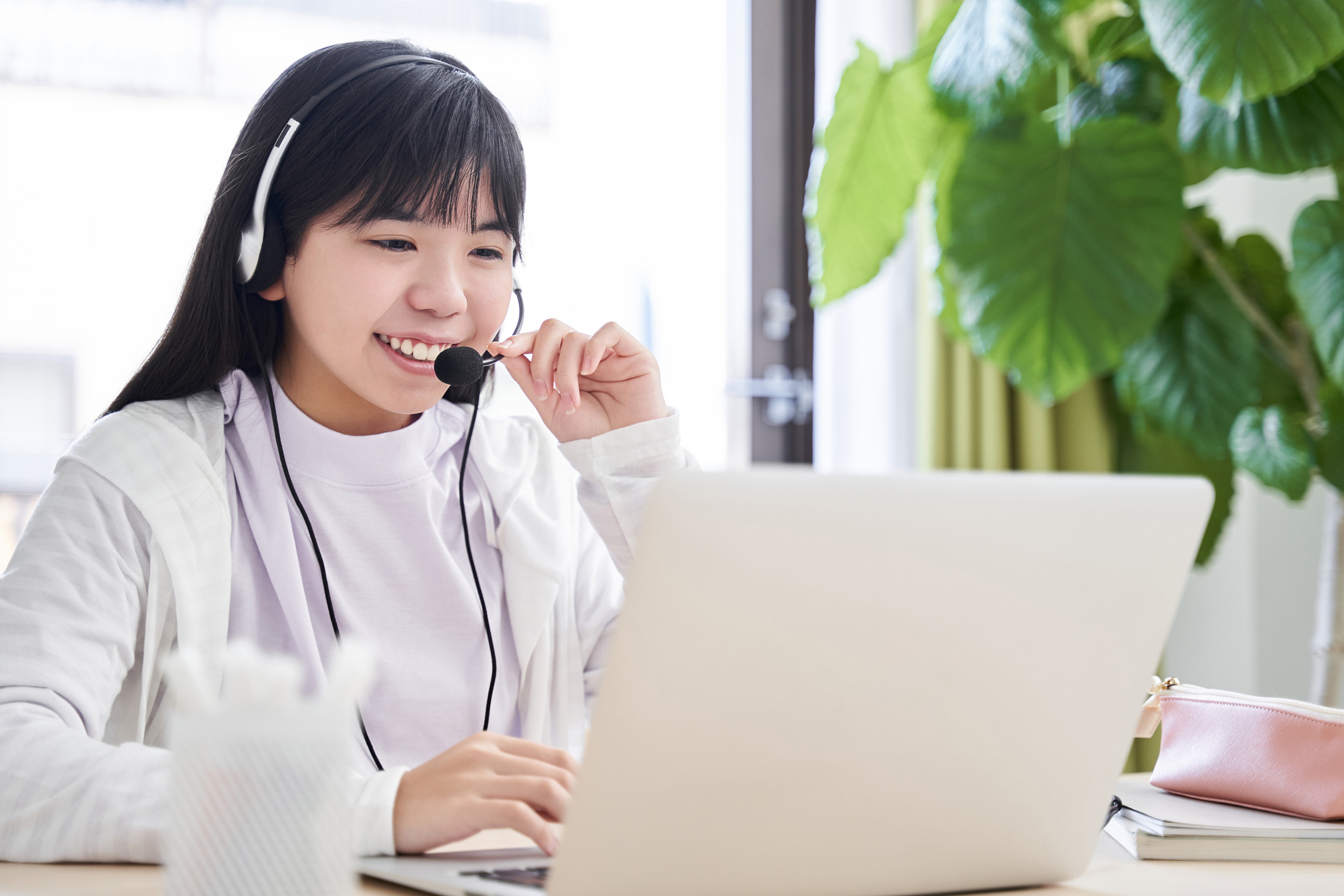 A Japanese junior high school girl attending an online lecture in her living room