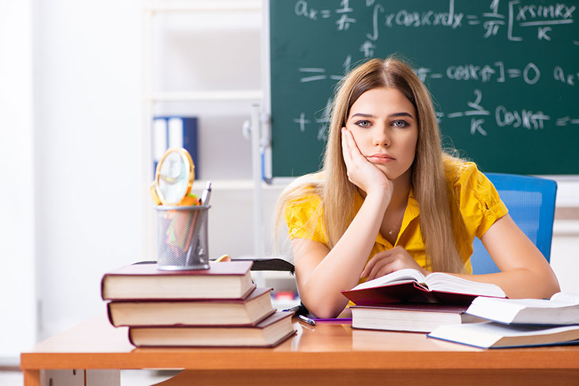 Young female student in front of the chalkboard